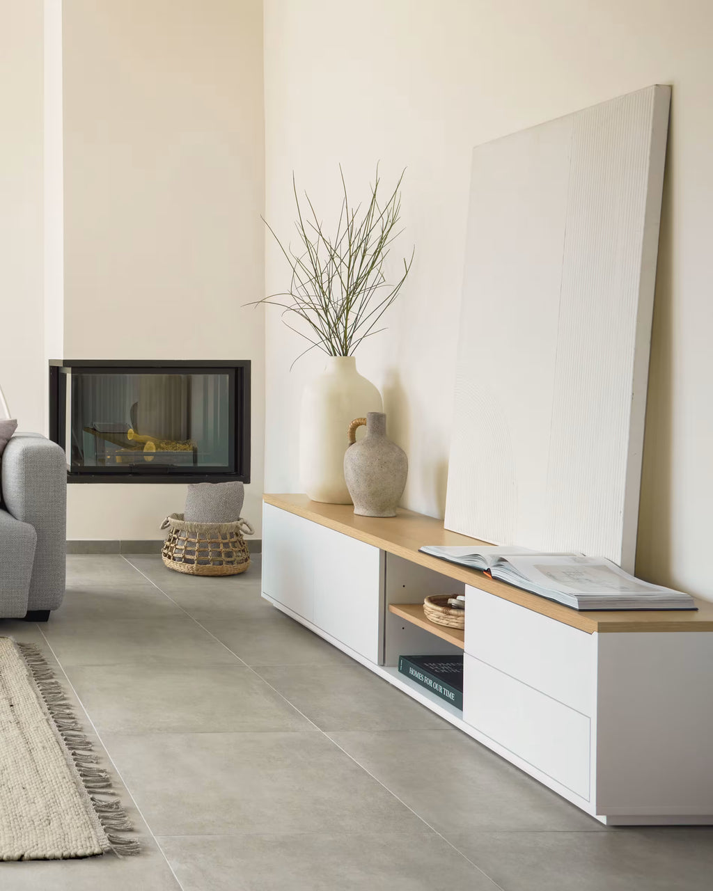 Modern living room with a white entertainment console, TV, and decorative items.