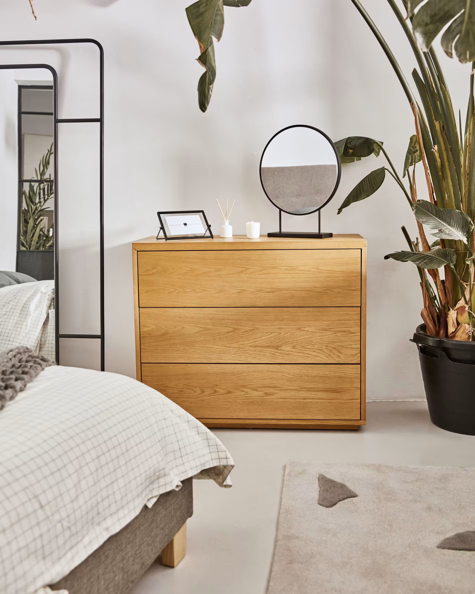 Wooden dresser in a bedroom with a mirror and decorative items.