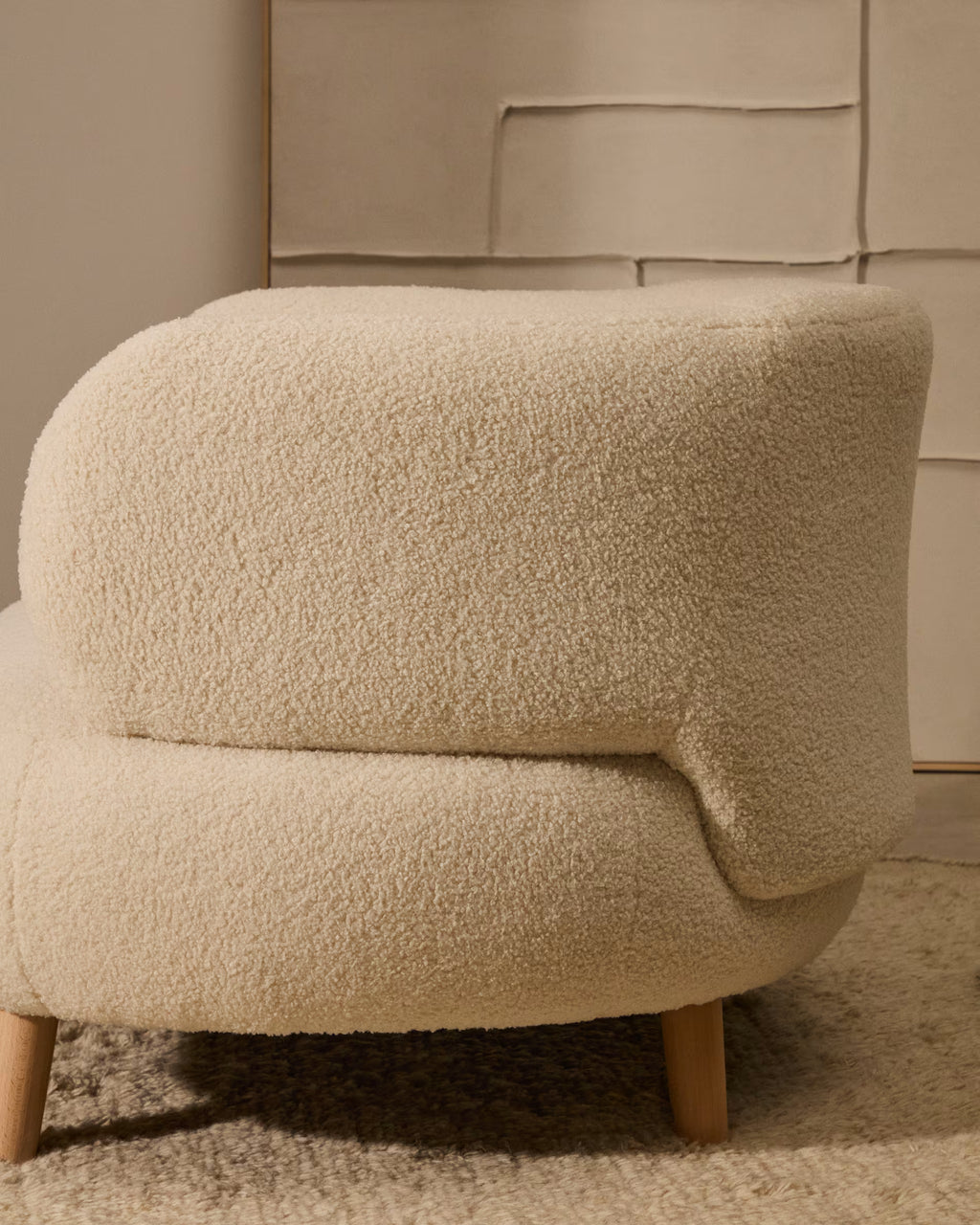 Beige textured armchair in a room with neutral walls.
