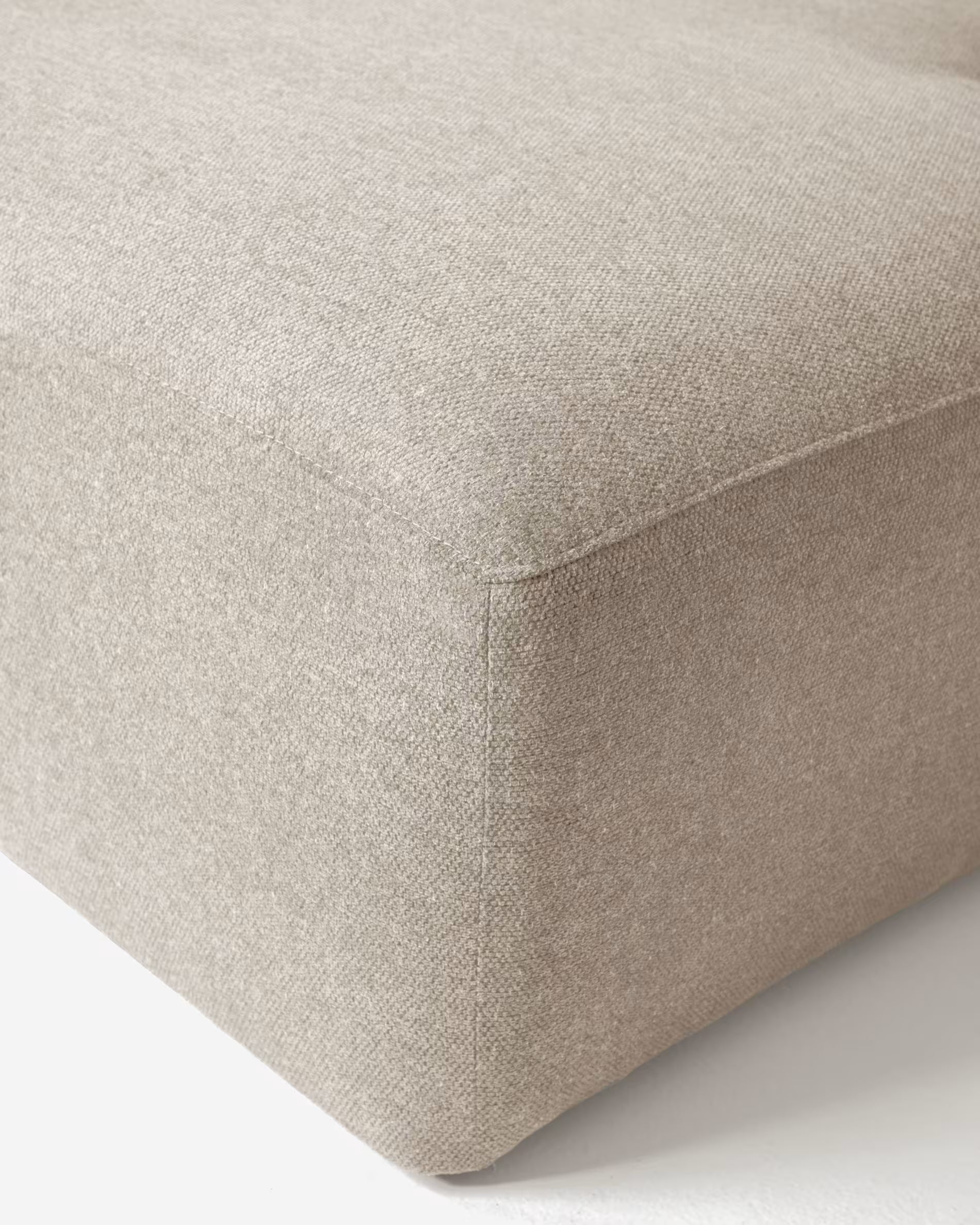 Close-up of a beige fabric surface with a subtle texture.