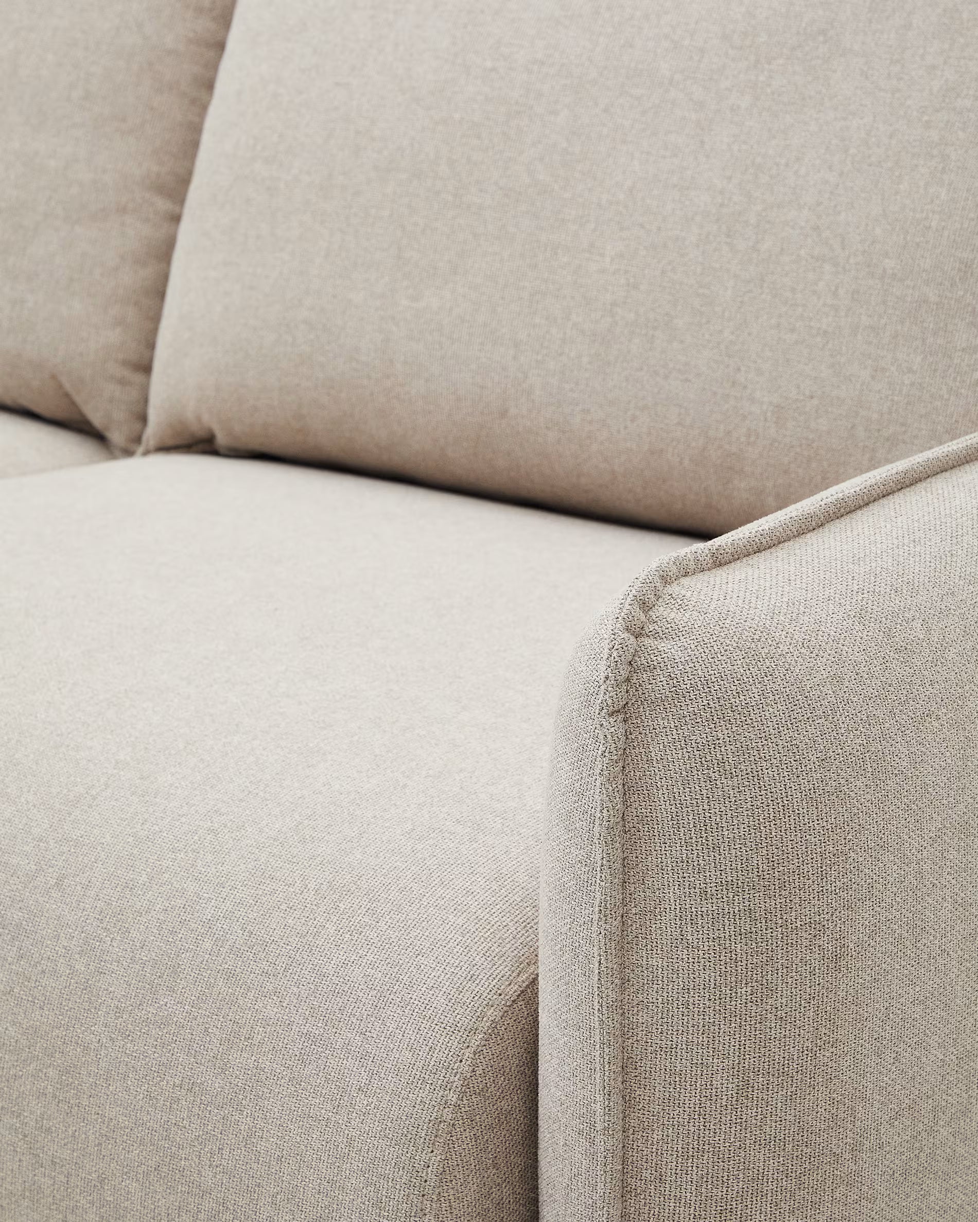 Close-up of a beige fabric sofa corner