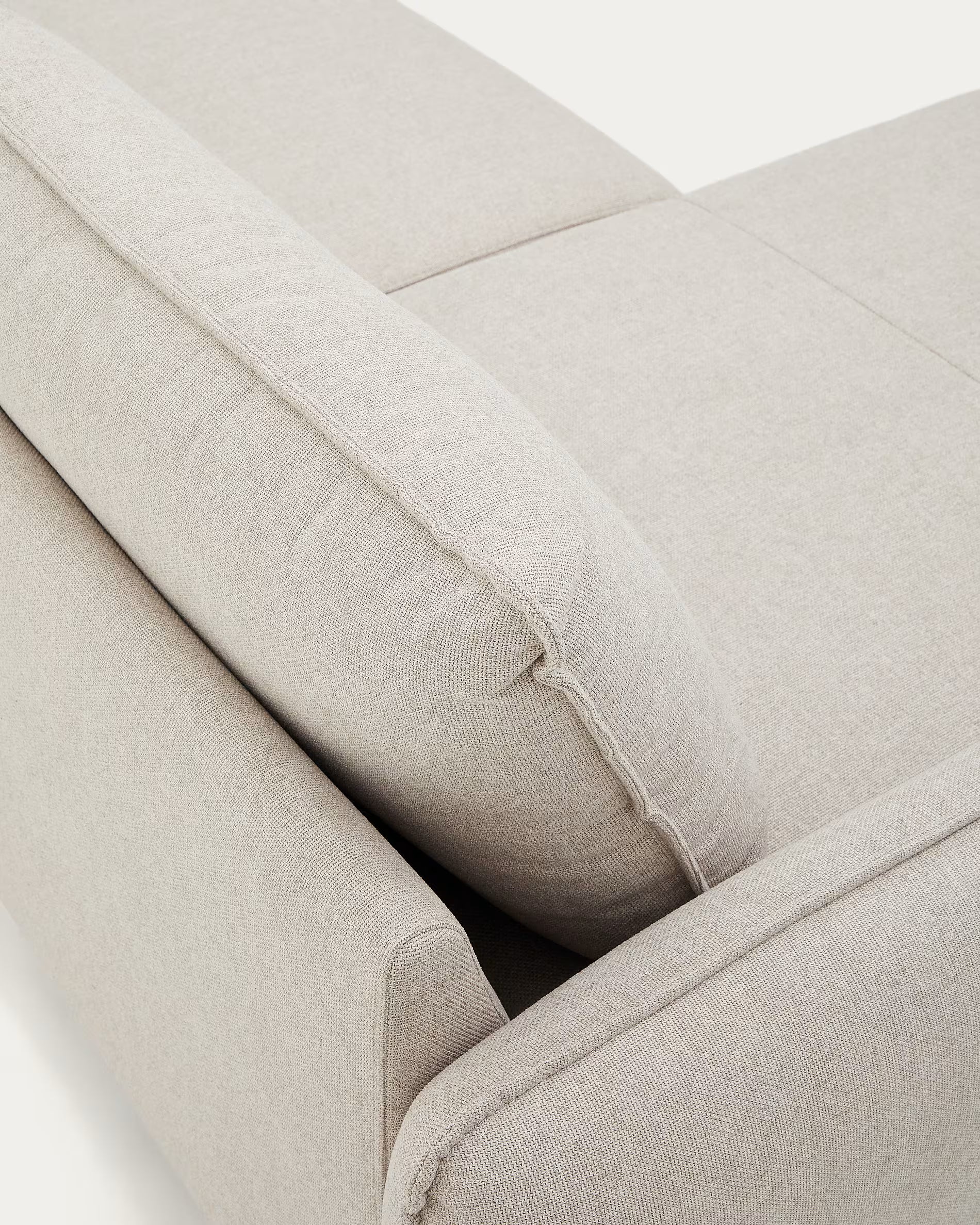 Close-up of a beige fabric sofa with visible stitching on a white background
