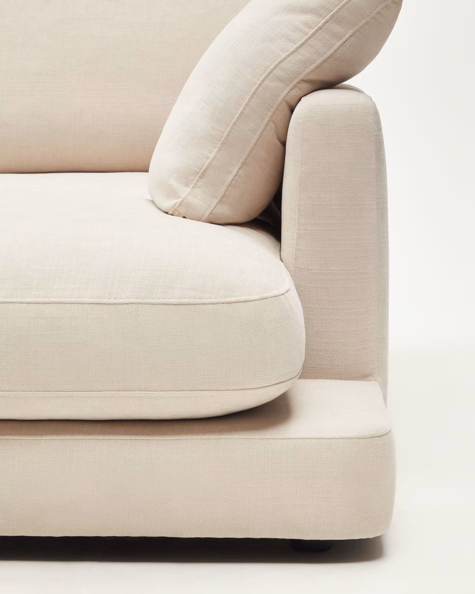 Beige sofa with a focus on cushioning and texture on a white background