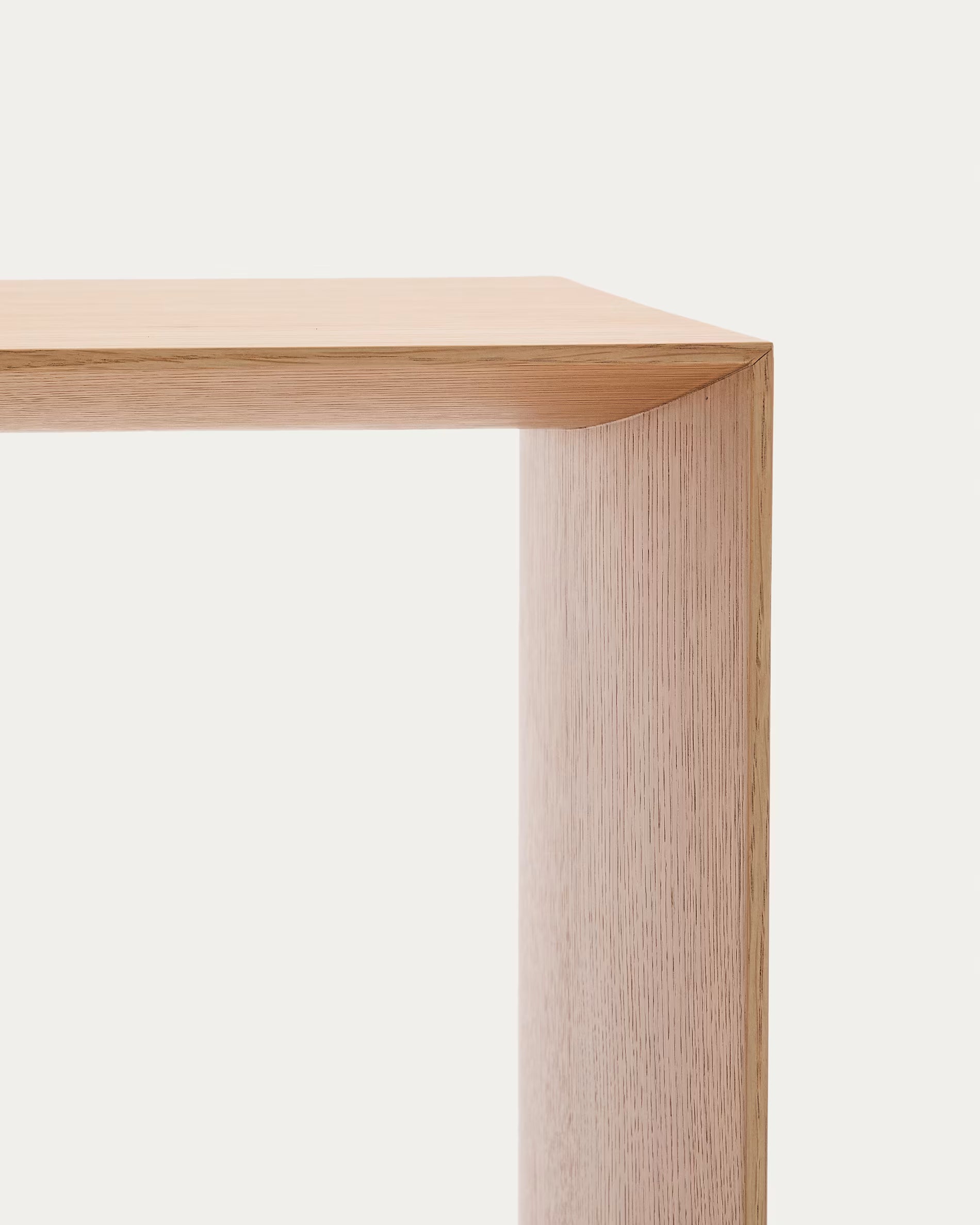 Close-up of a light wood rectangular table corner on a white background