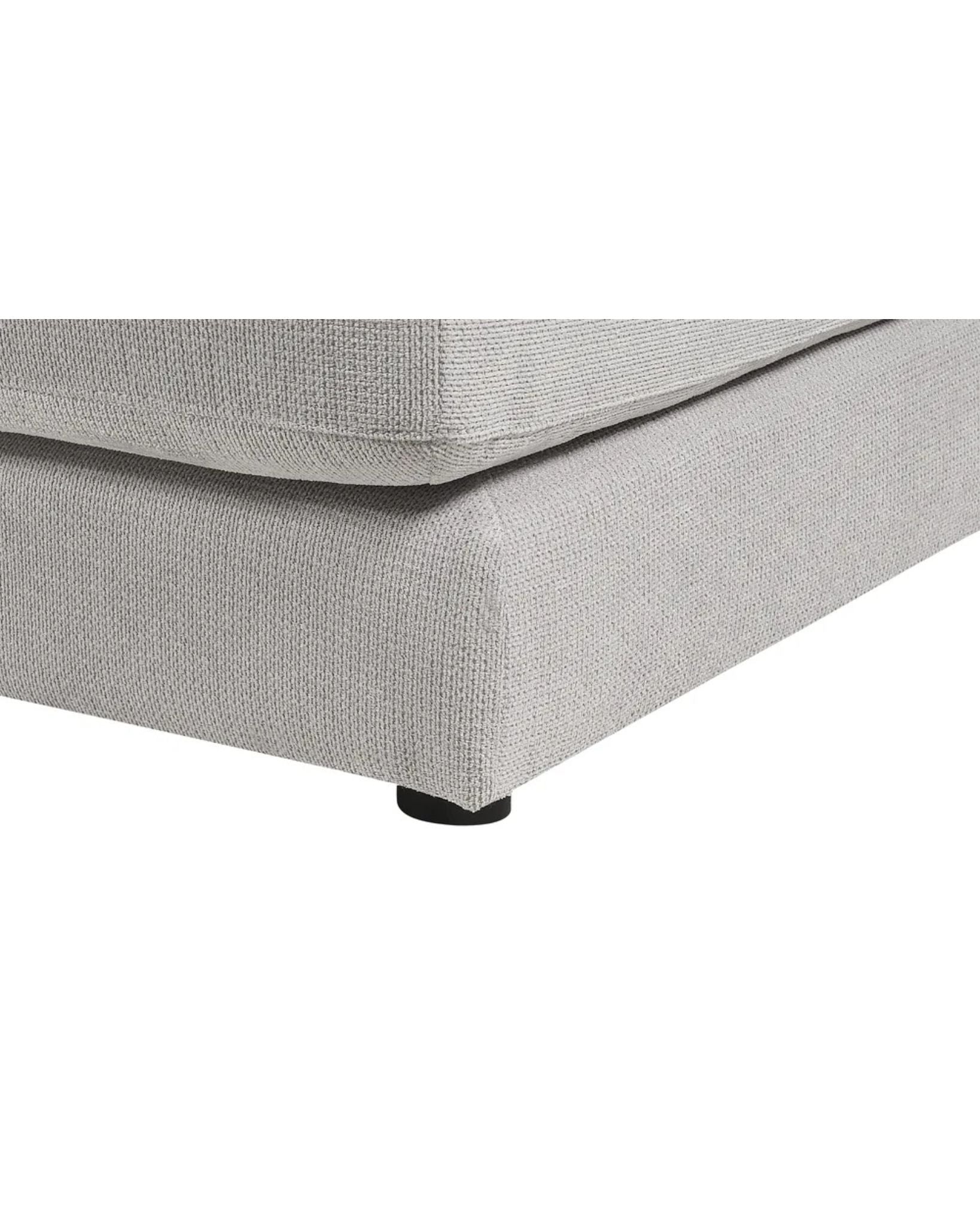 Gray upholstered bed corner on a white background