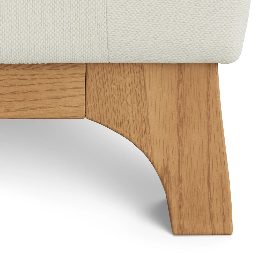 Close-up of a wooden bed frame with a white mattress.