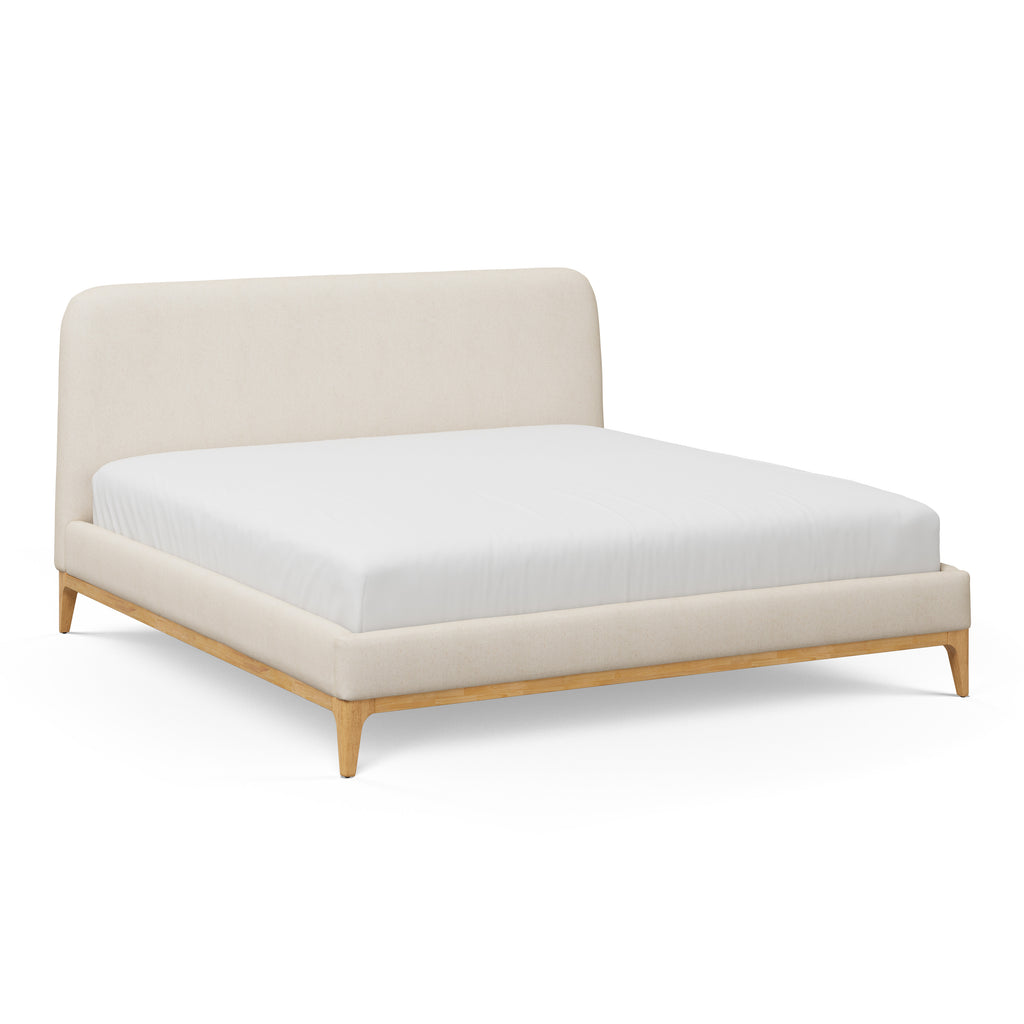 Beige upholstered bed with white mattress on a white background